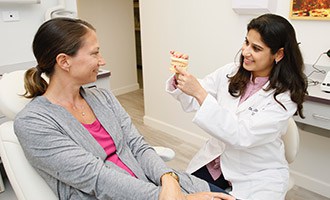 Cosmetic Dentist showing patient scale model of teeth