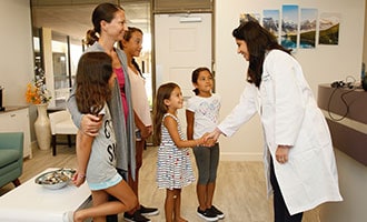 Dr. Bhave greeting children to the office