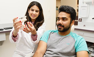 Dentist showing patient scale model for Dentures