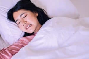 Woman tosses and turns at night while grinding her teeth