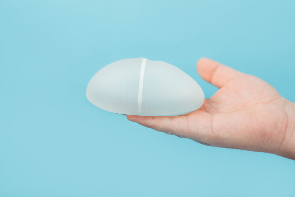 An open hand holds a breast implant before a quick recovery breast augmentation procedure