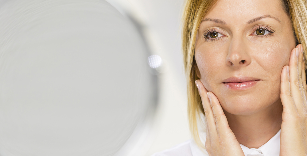 Woman looking in the mirror contemplating a facelift in Westchester County