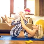 Beautiful woman in yoga pants, working out with her toddler following a mommy makeover