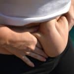 Woman squeezes extra skin and fat in Cleveland, considering liposuction or tummy tuck