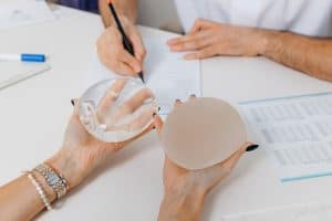 Patient having a consultation with her plastic surgeon about breast implant types before her revision surgery.