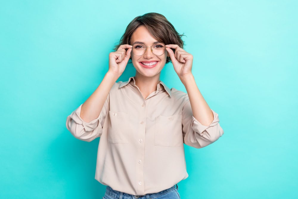 Woman holds glasses, but she is eager to have refractive surgery to ditch eyewear.