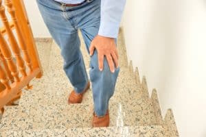 Senior man walking up the stairs, concerned about his balance due to cataracts.